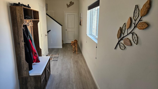 hallway with baseboards, stairway, and wood finished floors