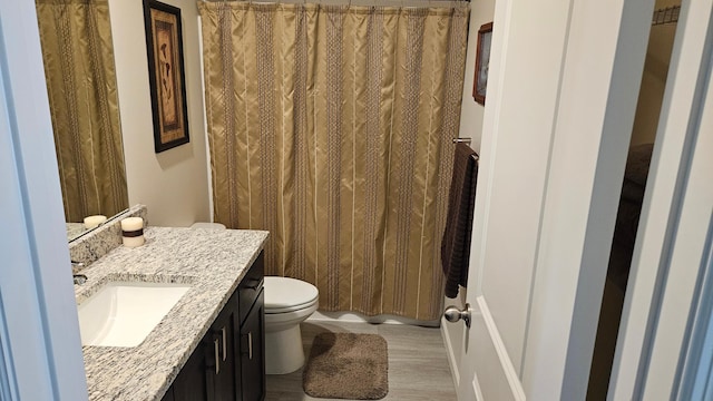 full bath with toilet, wood finished floors, vanity, and a shower with shower curtain