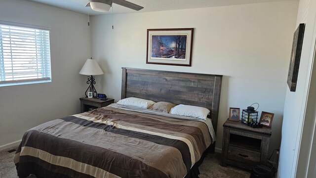 carpeted bedroom with ceiling fan and baseboards