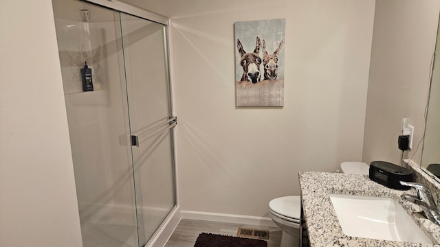 full bath with visible vents, a stall shower, baseboards, and toilet