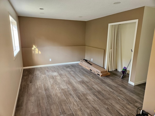 unfurnished room with dark wood-style flooring and baseboards