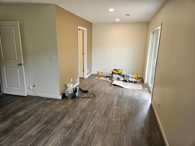 spare room featuring baseboards, dark wood-style floors, and recessed lighting