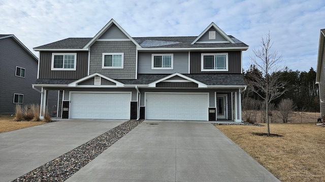 view of front facade with an attached garage, roof with shingles, driveway, and a front yard
