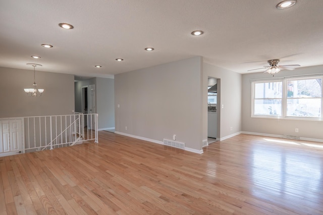 13100 Thomas Ave S, Burnsville, MN 55337 - unfurnished room with a chandelier, light wood finished floors, ceiling fan, recessed lighting, and a textured ceiling