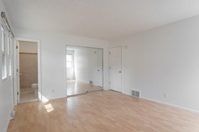 13100 Thomas Ave S, Burnsville, MN 55337 - unfurnished bedroom featuring light wood-type flooring and connected bathroom