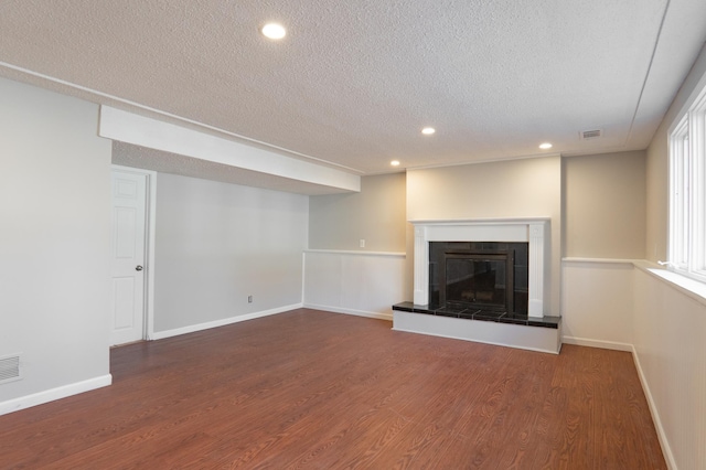 13100 Thomas Ave S, Burnsville, MN 55337 - unfurnished living room with a textured ceiling, wood finished floors, recessed lighting, and a tiled fireplace