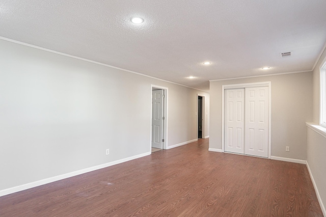 13100 Thomas Ave S, Burnsville, MN 55337 - unfurnished bedroom featuring dark wood-style flooring, ornamental molding, a closet, recessed lighting, and a textured ceiling