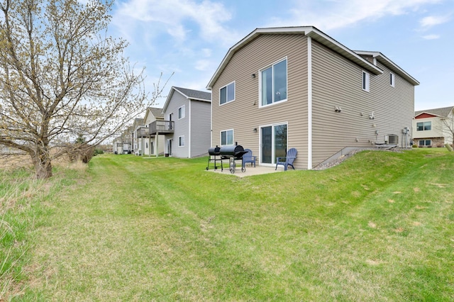 rear view of house with a patio, a yard, and central air condition unit