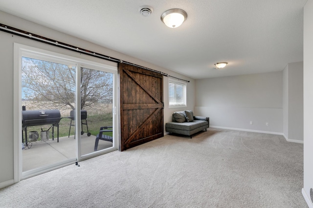 living area featuring carpet, a barn door, and baseboards
