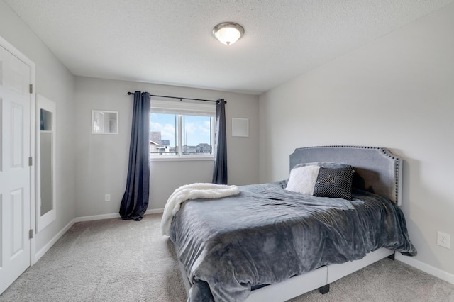 bedroom featuring a textured ceiling, carpet flooring, and baseboards
