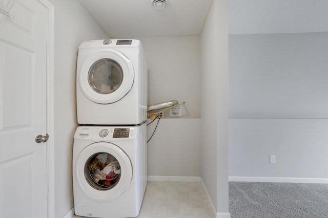 washroom featuring stacked washer and dryer and baseboards