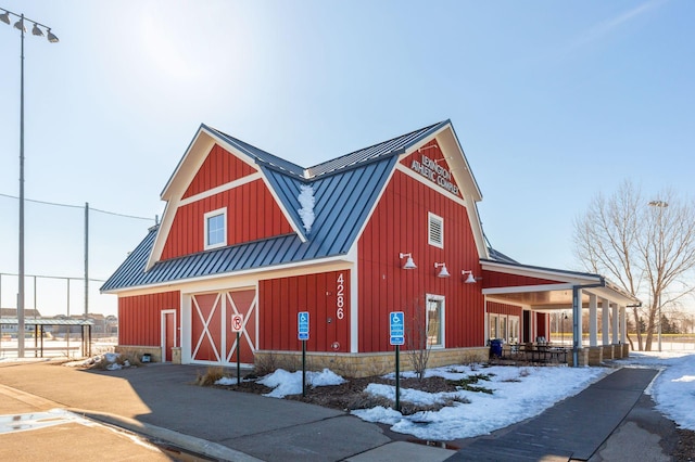 snow covered structure with a barn and an outbuilding