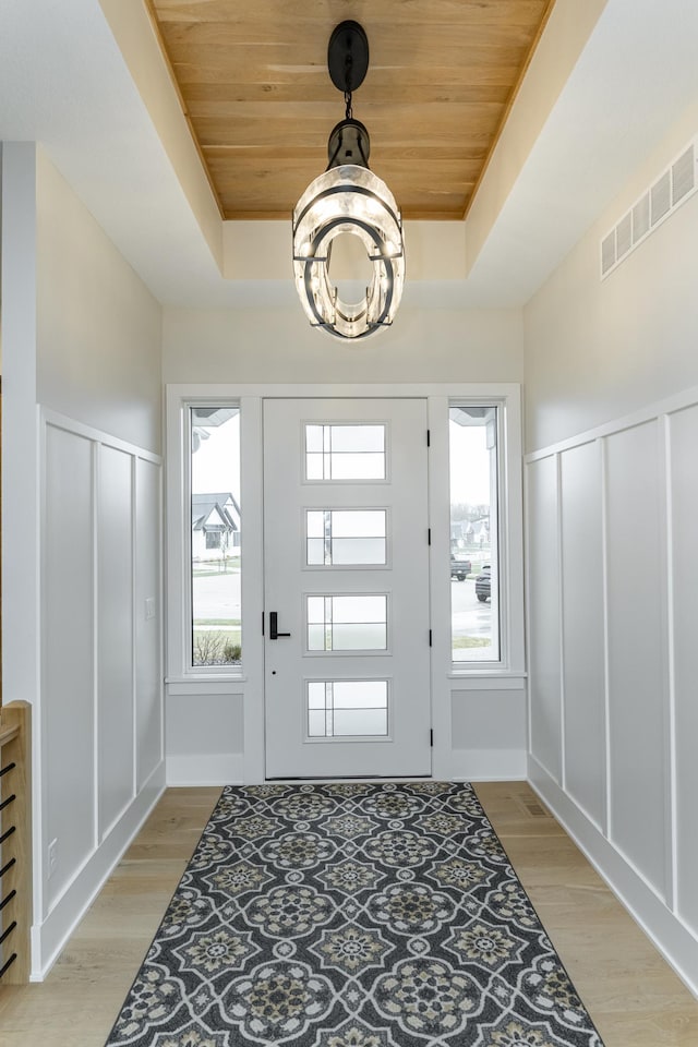 3251 Century Ridge Pl NE, Rochester, MN 55906 - entryway featuring a raised ceiling, wooden ceiling, a chandelier, light wood-style flooring, and a decorative wall