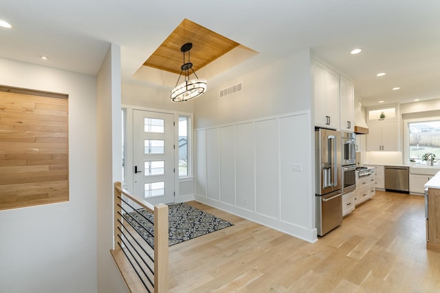 3251 Century Ridge Pl NE, Rochester, MN 55906 - entryway with light wood-type flooring, a raised ceiling, a decorative wall, wainscoting, and recessed lighting