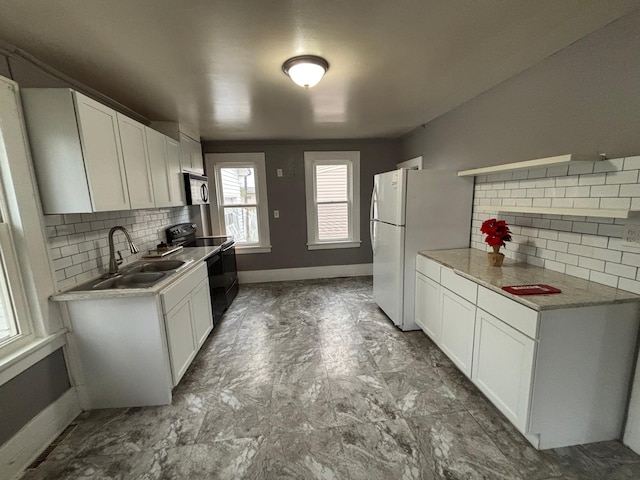 1017 Prairie St, Lake City, MN 55041 - kitchen featuring white cabinetry, light countertops, a sink, freestanding refrigerator, and black electric range