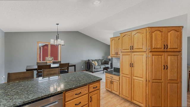 kitchen with an inviting chandelier, light wood finished floors, vaulted ceiling, and stainless steel dishwasher