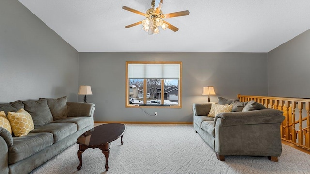 living area featuring baseboards, a ceiling fan, and light carpet