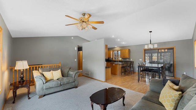 living area featuring ceiling fan, light wood-style flooring, visible vents, and lofted ceiling