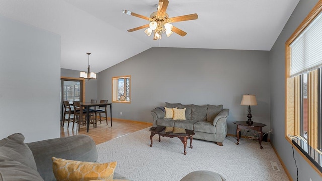 living room with a ceiling fan, baseboards, wood finished floors, lofted ceiling, and visible vents