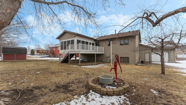 snow covered rear of property featuring a sunroom, fence, an outbuilding, and stairway