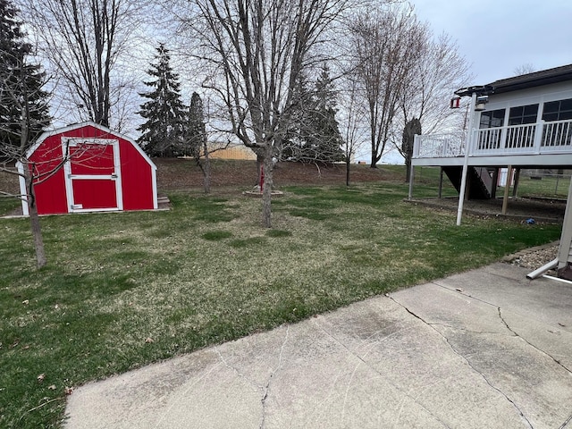 view of yard featuring a deck, an outbuilding, and a shed
