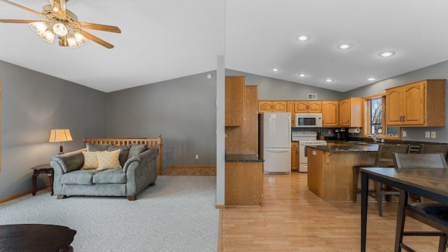 328 5th Ave S, Sartell, MN 56377 - kitchen with white appliances, vaulted ceiling, a ceiling fan, light wood-type flooring, and a peninsula