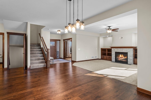 27290 Petes Hill Trl, Elko New Market, MN 55020 - unfurnished living room with a fireplace with flush hearth, visible vents, stairway, baseboards, and hardwood / wood-style flooring