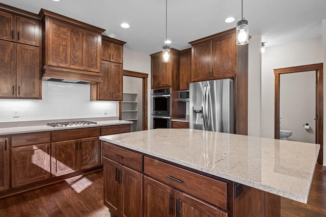 27290 Petes Hill Trl, Elko New Market, MN 55020 - kitchen with appliances with stainless steel finishes, dark wood-style floors, pendant lighting, decorative backsplash, and a kitchen island