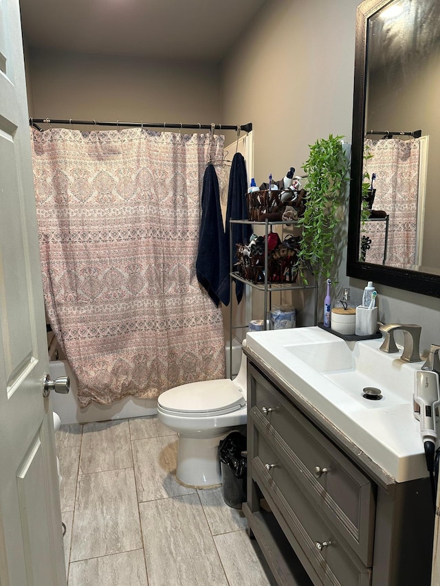 full bathroom featuring toilet, shower / bath combination with curtain, and vanity