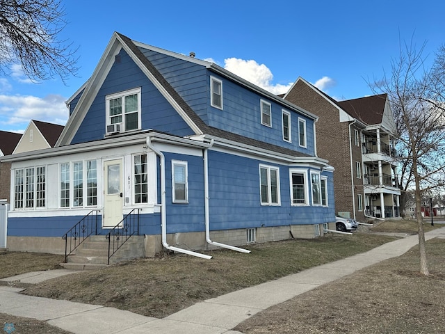view of side of home featuring entry steps and a shingled roof