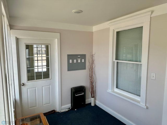 doorway to outside featuring baseboards, heating unit, and electric panel
