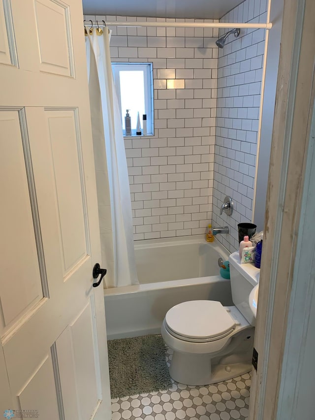 bathroom featuring tile patterned floors, toilet, and shower / bath combination with curtain