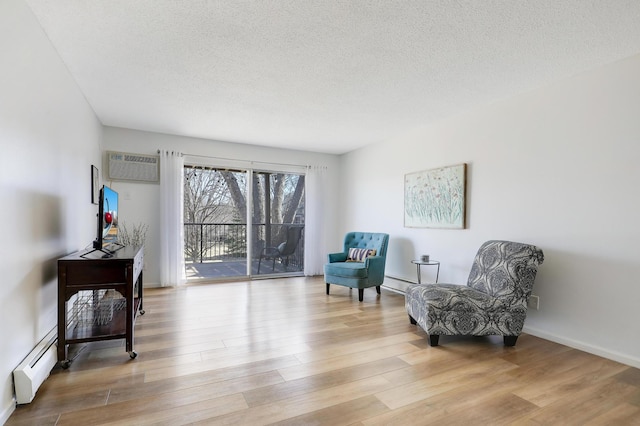 2800 Hillsboro Ave N Unit 220, New Hope, MN 55427 - living area with a baseboard radiator, a textured ceiling, wood finished floors, baseboard heating, and a wall mounted AC