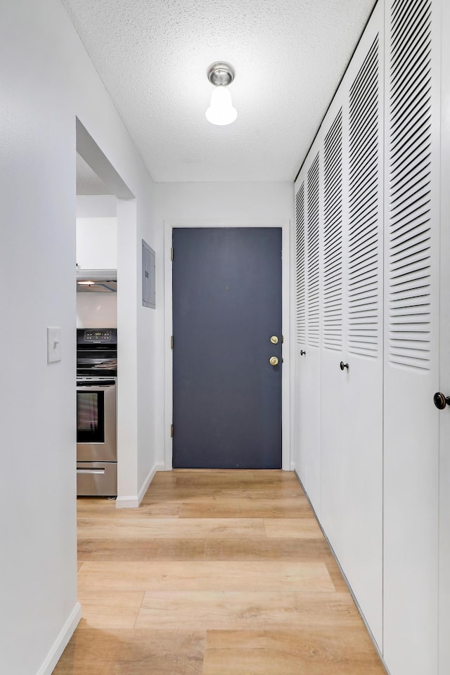 2800 Hillsboro Ave N Unit 220, New Hope, MN 55427 - hallway featuring light wood-style flooring, electric panel, and a textured ceiling