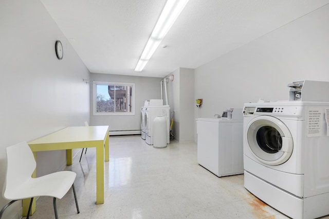 2800 Hillsboro Ave N Unit 220, New Hope, MN 55427 - community laundry featuring washer and dryer, a baseboard heating unit, and light floors