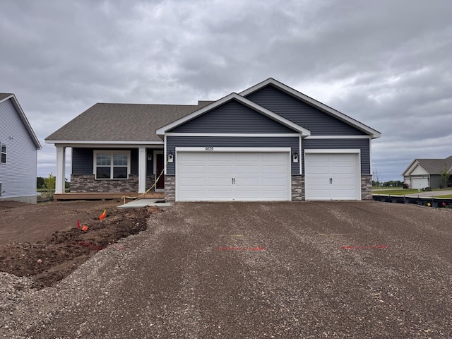 9829 89th St S, Cottage Grove, MN 55016 - view of front of house with asphalt driveway, an attached garage, and stone siding