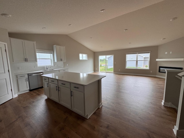 9829 89th St S, Cottage Grove, MN 55016 - kitchen with stainless steel dishwasher, vaulted ceiling, dark wood-type flooring, white cabinets, and a center island