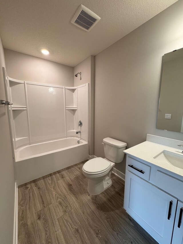 9829 89th St S, Cottage Grove, MN 55016 - full bath featuring wood finished floors, toilet, tub / shower combination, vanity, and a textured ceiling