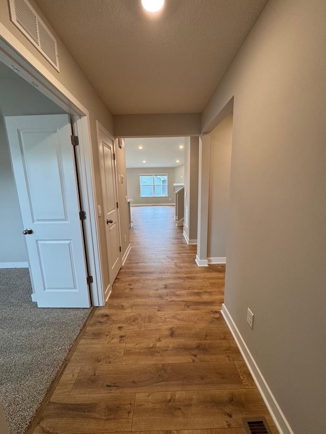 9829 89th St S, Cottage Grove, MN 55016 - hall featuring wood finished floors, baseboards, a textured ceiling, and recessed lighting