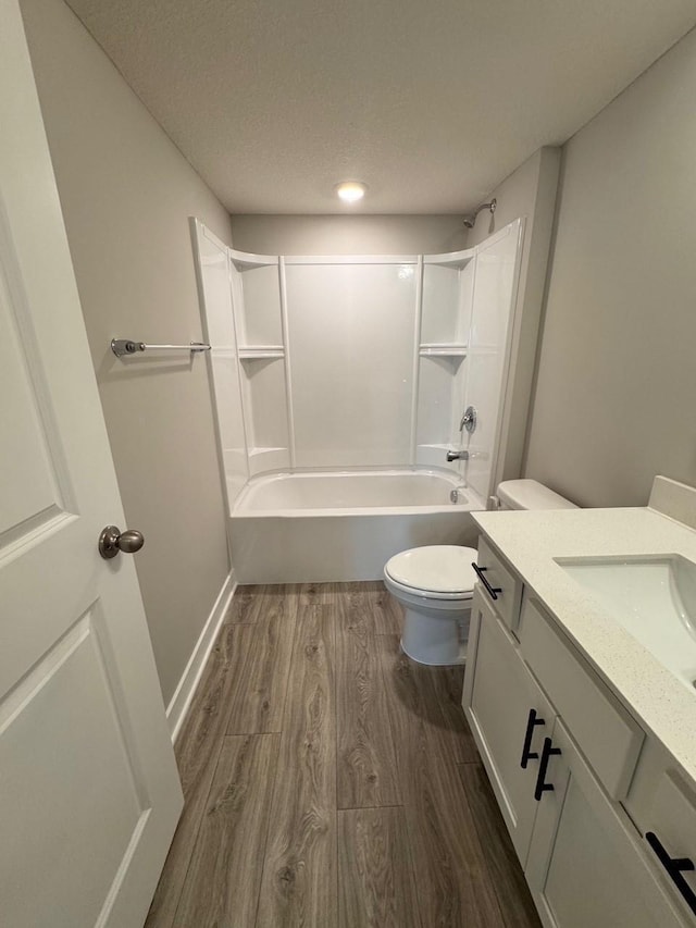 9829 89th St S, Cottage Grove, MN 55016 - bathroom featuring wood finished floors, toilet, bathtub / shower combination, a textured ceiling, and vanity