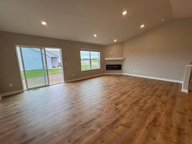 9829 89th St S, Cottage Grove, MN 55016 - unfurnished living room with wood finished floors, recessed lighting, a glass covered fireplace, baseboards, and vaulted ceiling
