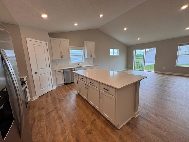 9829 89th St S, Cottage Grove, MN 55016 - kitchen with stainless steel appliances, lofted ceiling, dark wood finished floors, white cabinets, and light countertops