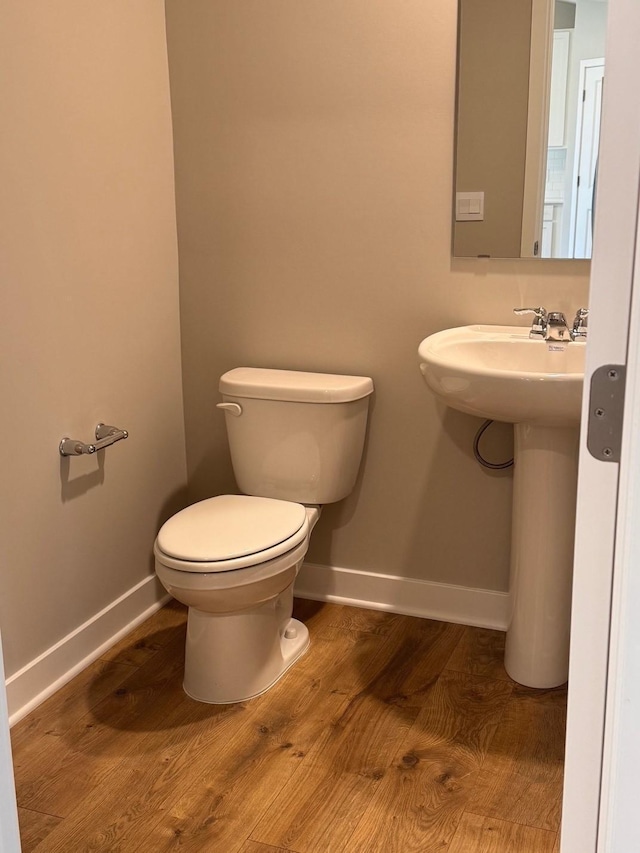 9829 89th St S, Cottage Grove, MN 55016 - bathroom featuring wood finished floors, baseboards, and toilet