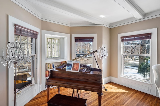 living area with crown molding, wood finished floors, a notable chandelier, and beam ceiling