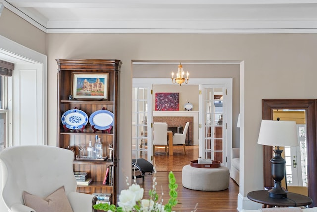 living area with french doors, an inviting chandelier, and wood finished floors