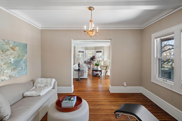 living area featuring crown molding, baseboards, wood finished floors, and a notable chandelier