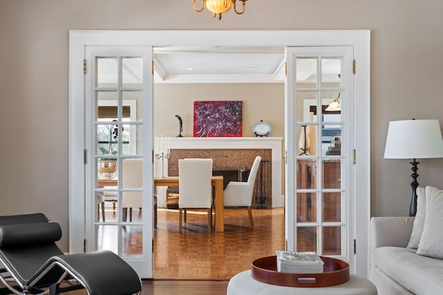 living area featuring a notable chandelier, ornamental molding, and wood finished floors