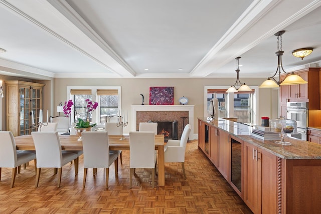 dining area featuring a high end fireplace, baseboards, crown molding, and beamed ceiling