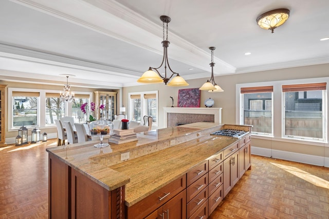 kitchen featuring plenty of natural light, baseboards, a kitchen island, and light stone countertops