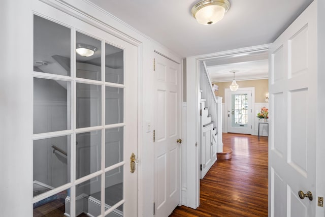 corridor featuring ornamental molding and dark wood-style flooring